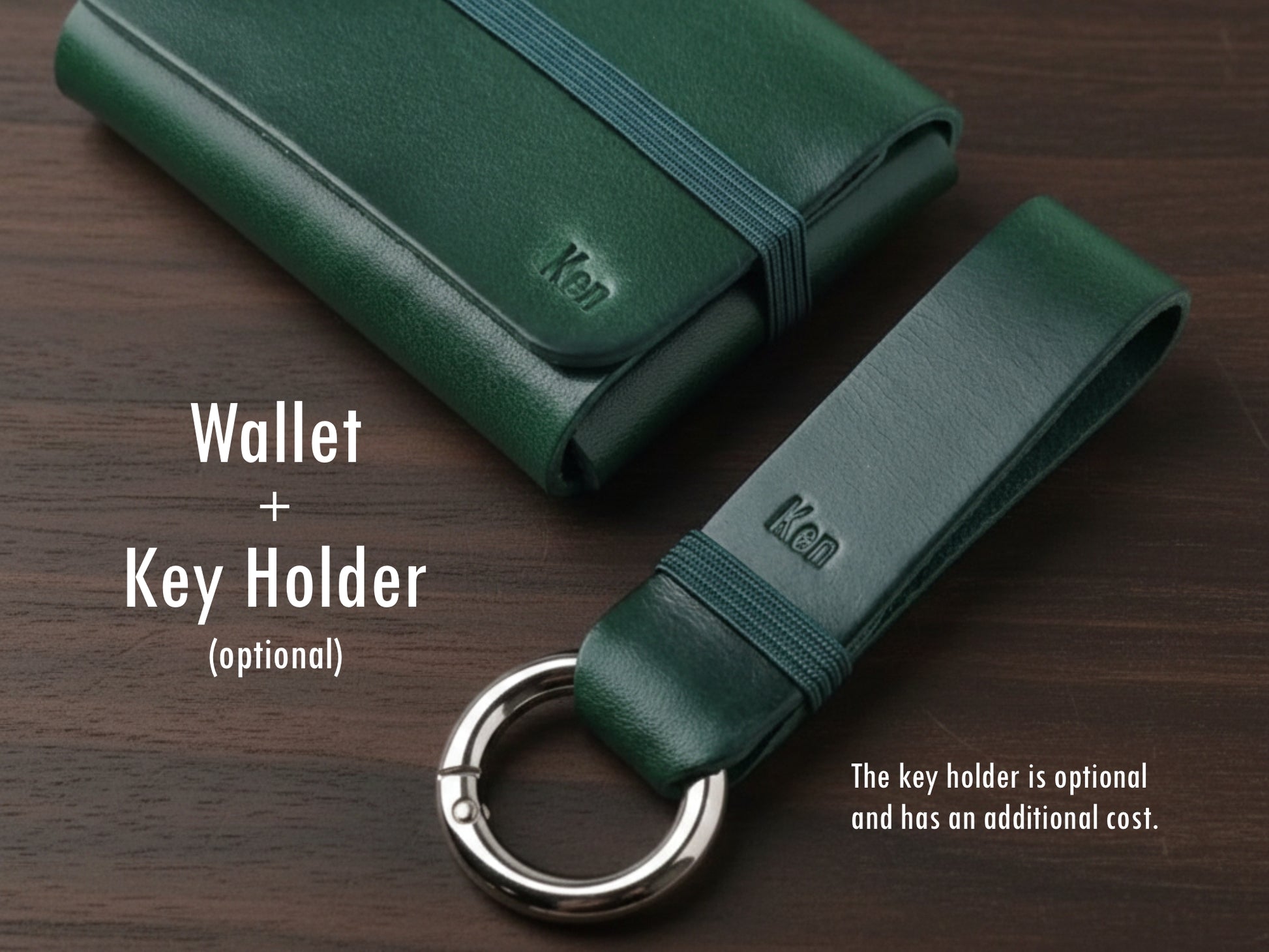 Carteira em couro alpine green com elástico verde sobre fundo de madeira escura, acompanhado de um porta-chaves combinando. No canto inferior direito, um aviso indica que o porta-chaves é opcional e possui custo adicional.